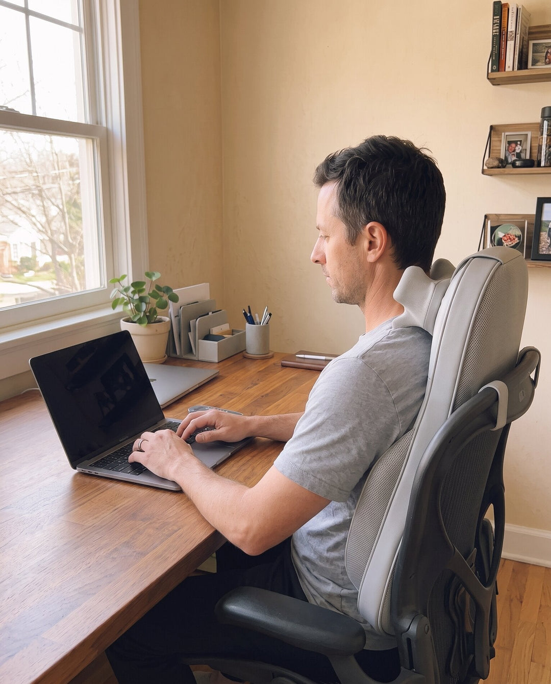 The Sereno on a desk chair while a man works at his laptop