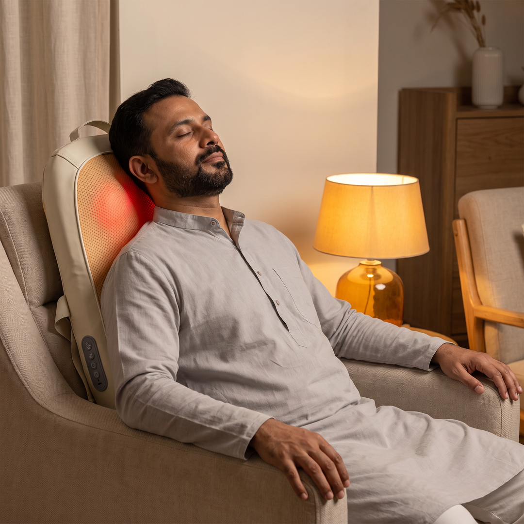 A man resting in an armchair in the evening with The Lume behind his upper back