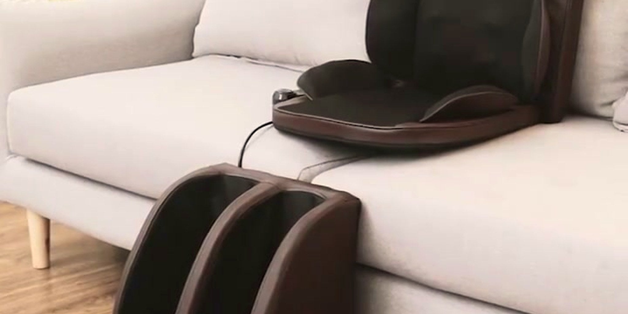 The Grande full-body massage lounger with calf unit set up on a grey sofa