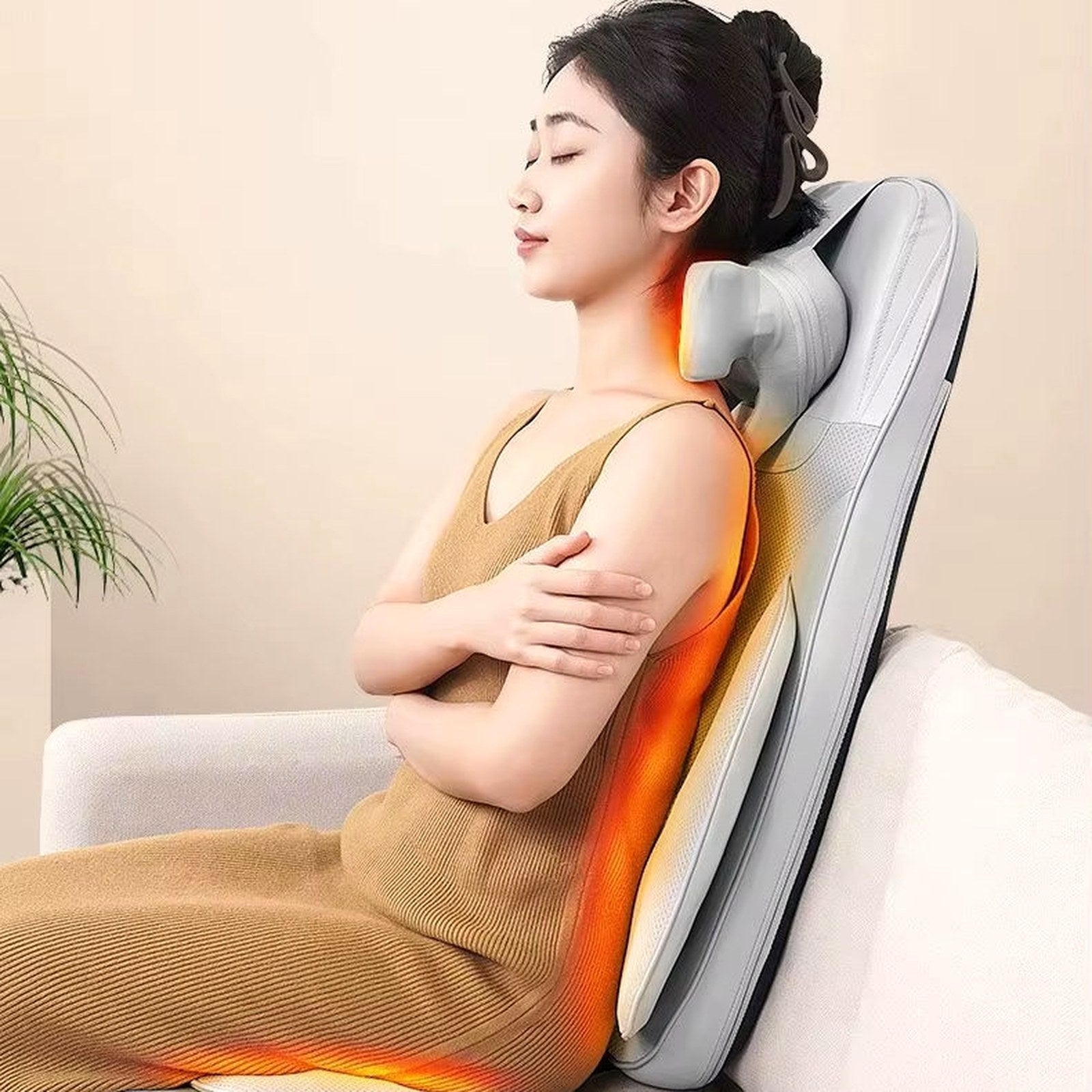 Woman relaxing on The Sereno massage seat placed on a cream armchair